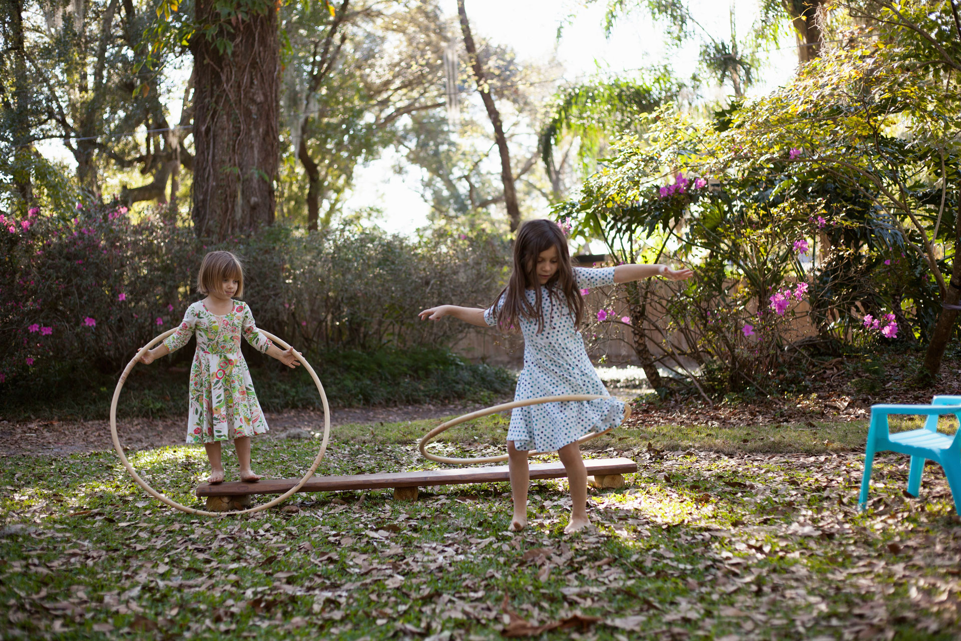 Bambine giocano in un giardino all'ombra.